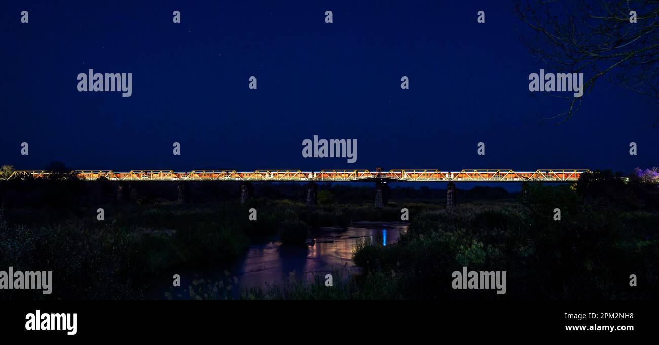 The train on the bridge over Sabie river at Skukuza at night, Kruger national park, South Africa. Stock Photo