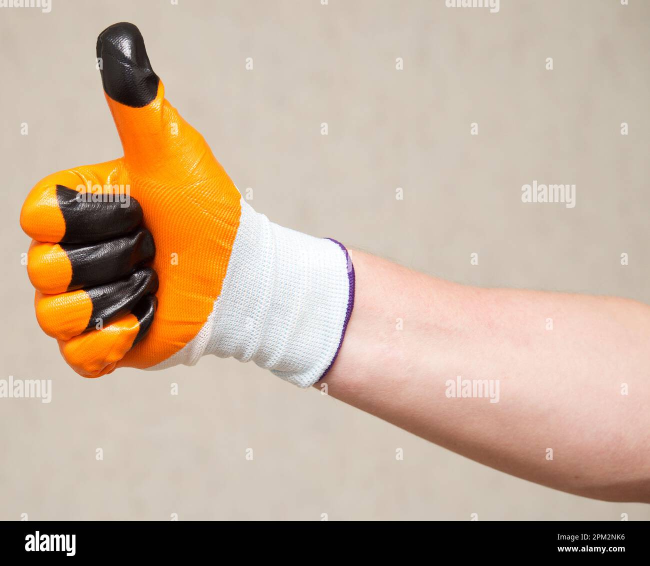 Hand in glove showing thumbs up Stock Photo - Alamy