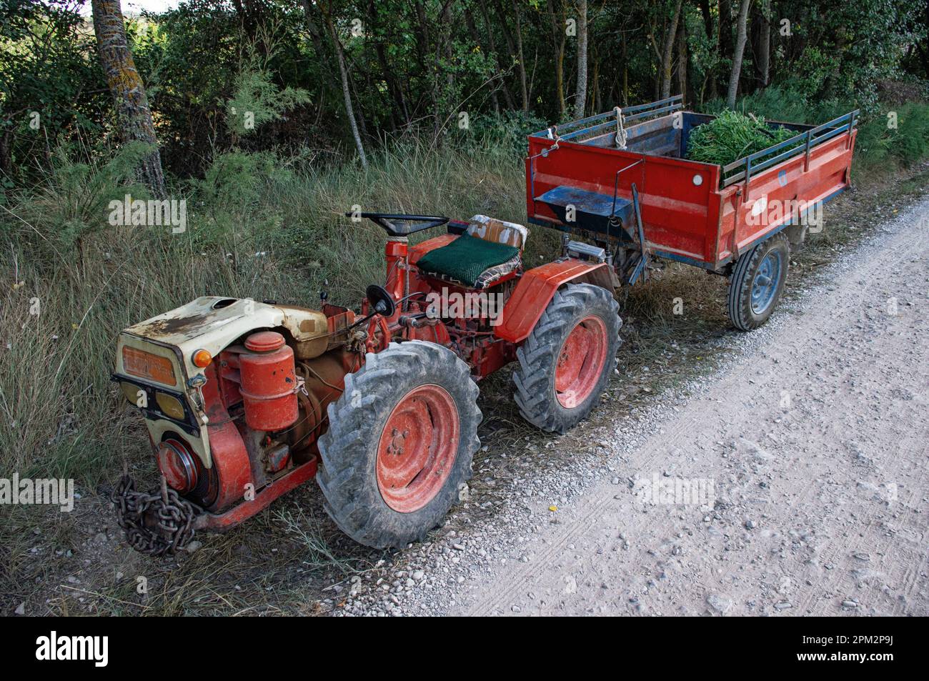 Old red tractor on roadside when finishing field tasks Stock Photo - Alamy