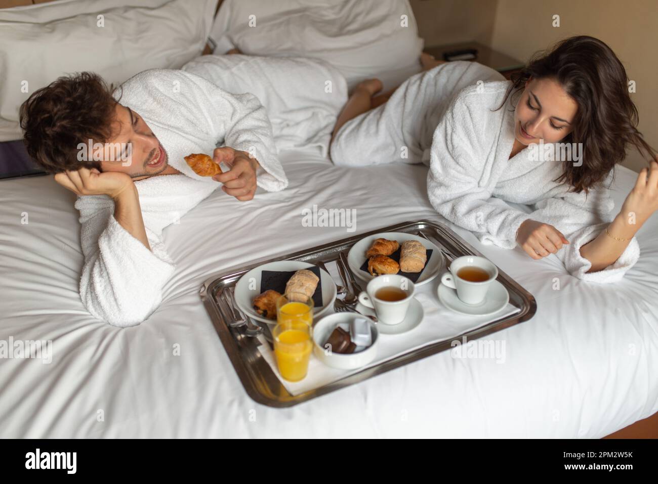 Young couple doing breakfast in the bed Stock Photo - Alamy