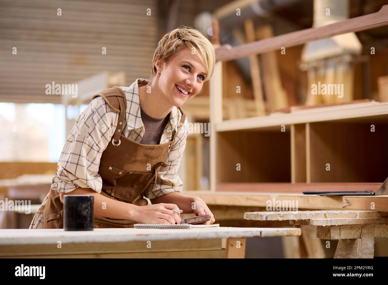 Female Apprentice Working As Carpenter In Furniture Workshop Stock ...