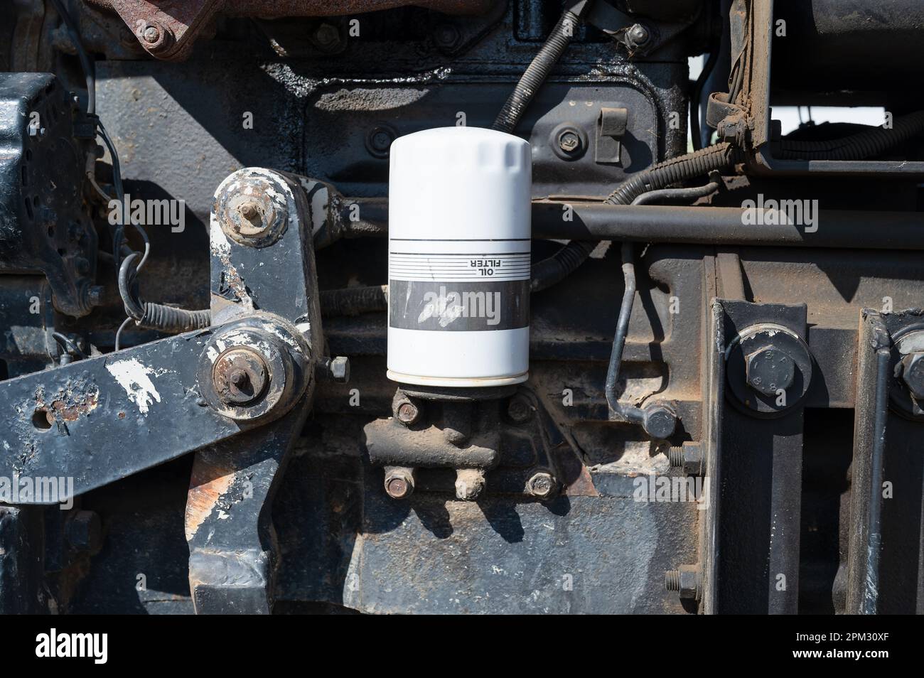 Oil filter mounted upside down on the side of a typical working farm