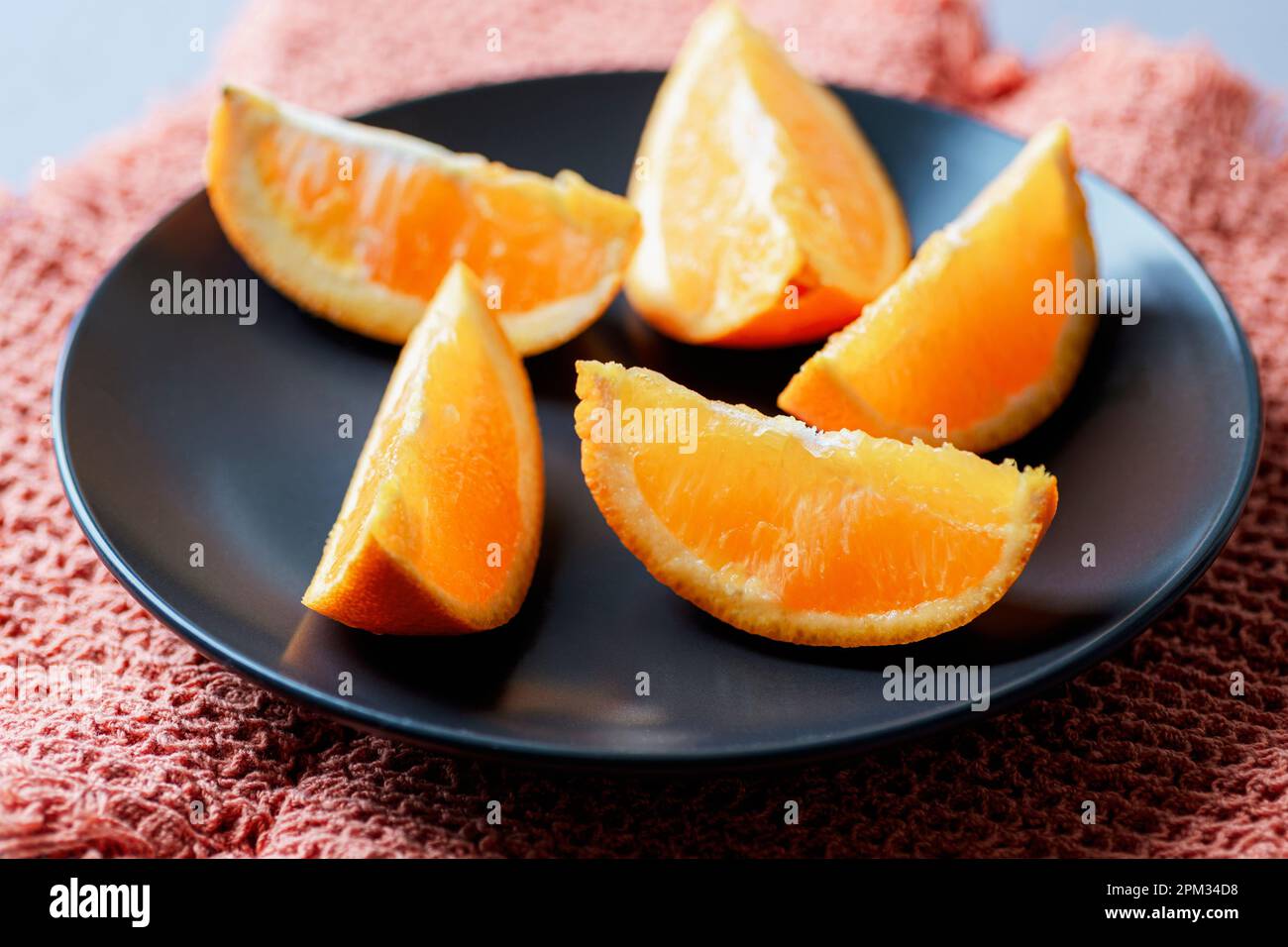 Orange slices on black plate, closeup. Selective focus. Stock Photo