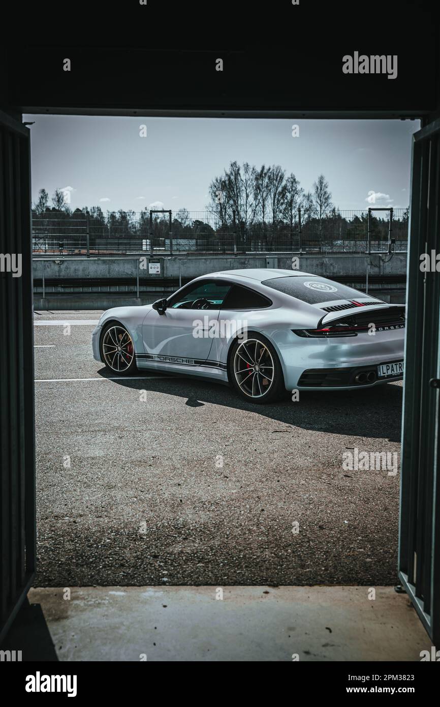 A vertical shot from a door opening to a parked Porsche outdoors Stock ...
