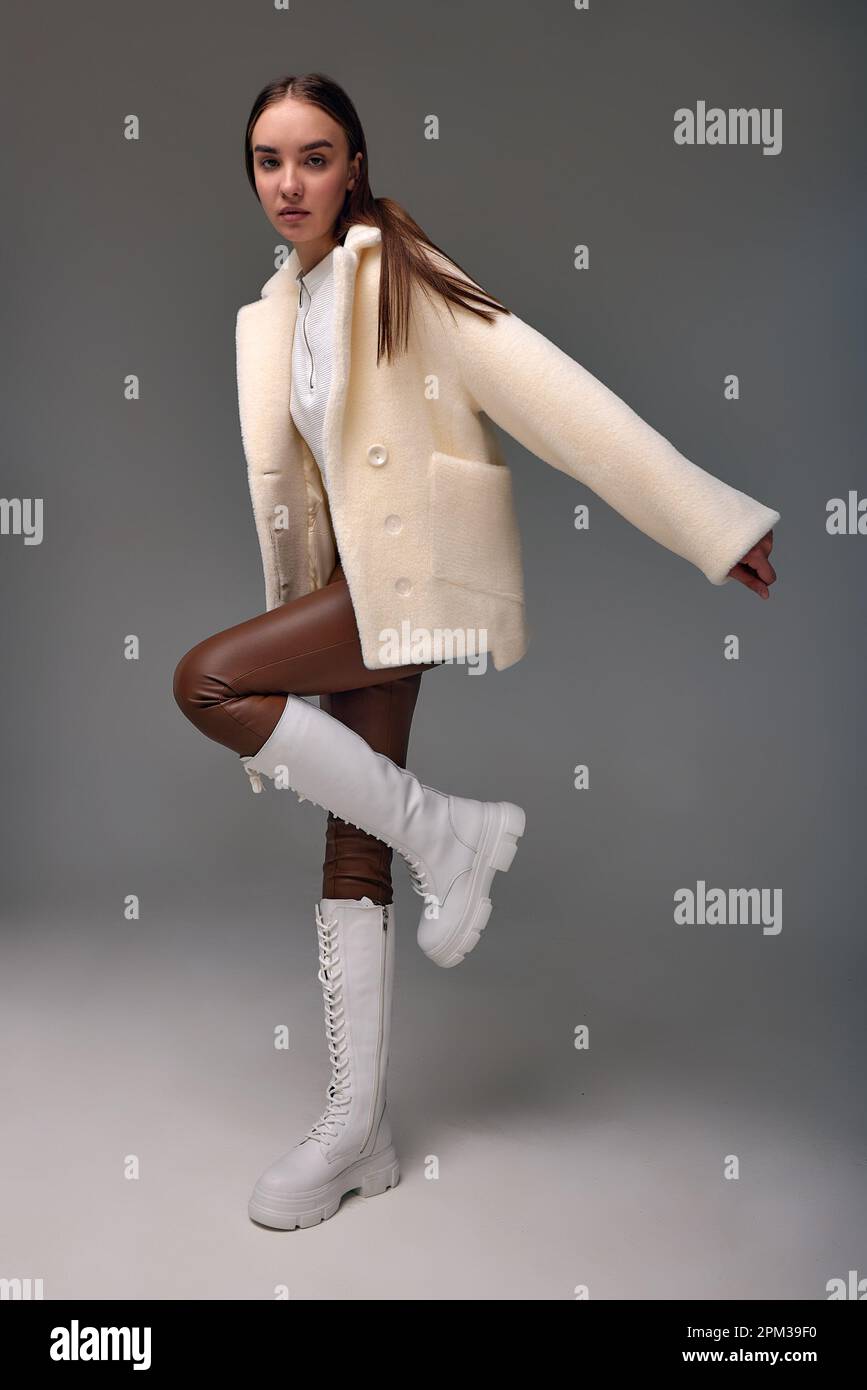 A beautiful business woman in a fur coat on a light background, a photo ...