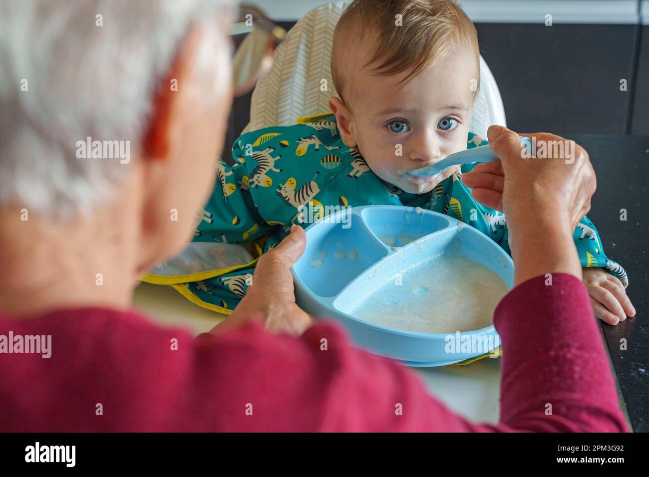 Grandmother feeding her grandson Stock Photo