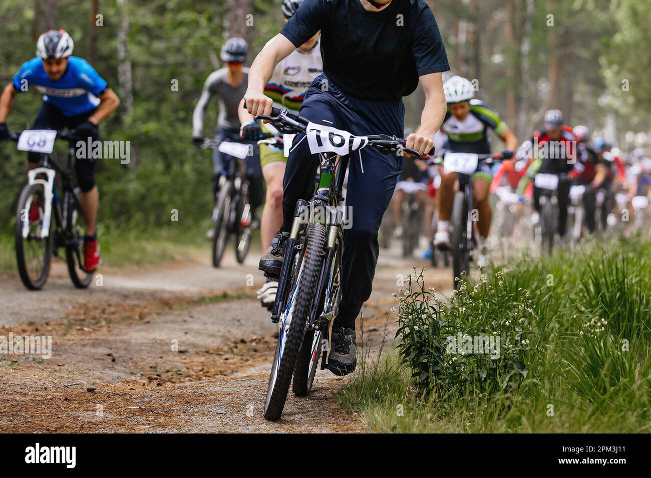 leader cyclist ahead group athlete mountainbikers riding cross-country cycling competition Stock Photo