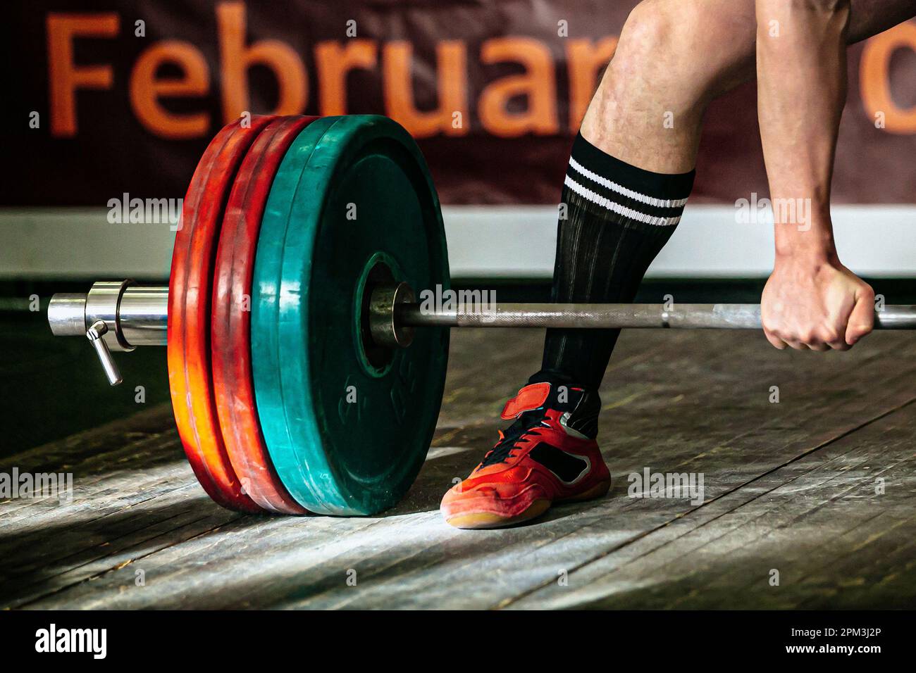 part barbell and body powerlifter stand on wooden floor, powerlifting competition deadlift Stock Photo