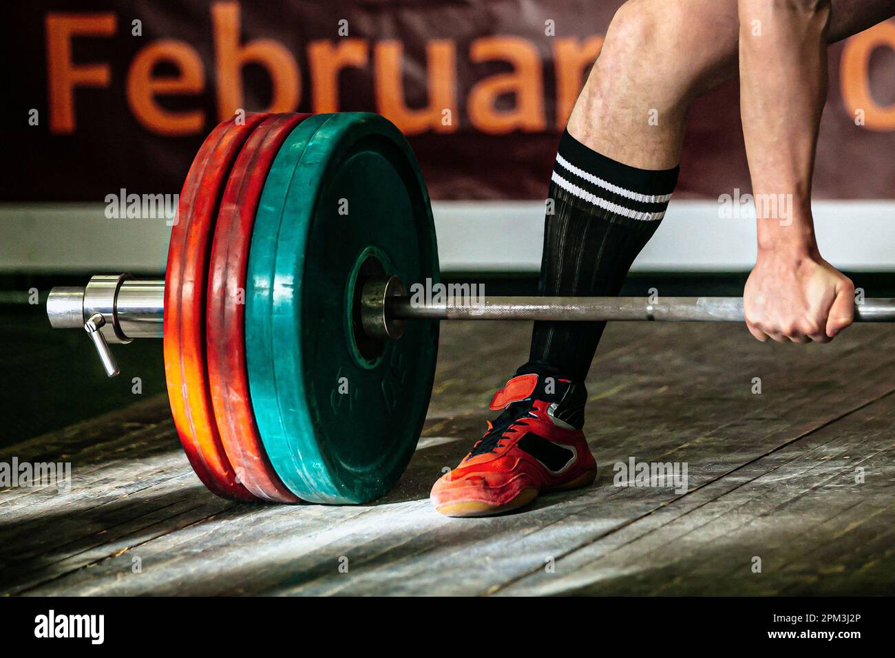 part barbell and body powerlifter stand on wooden floor