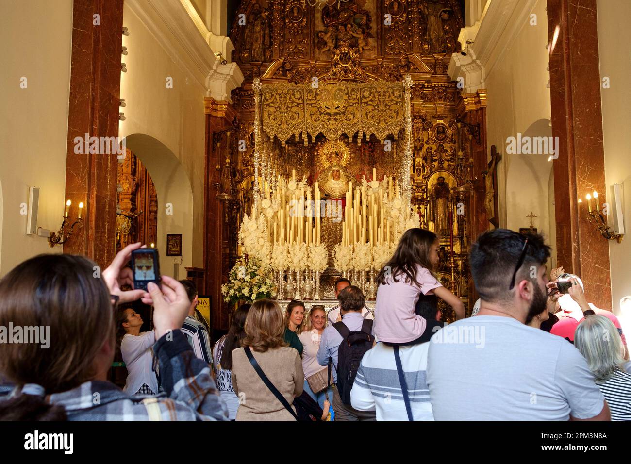Seville Spain - Visitors to a church in Seville to view the A Paso. (It is an elaborate float made for religious processions). Seville Stock Photo