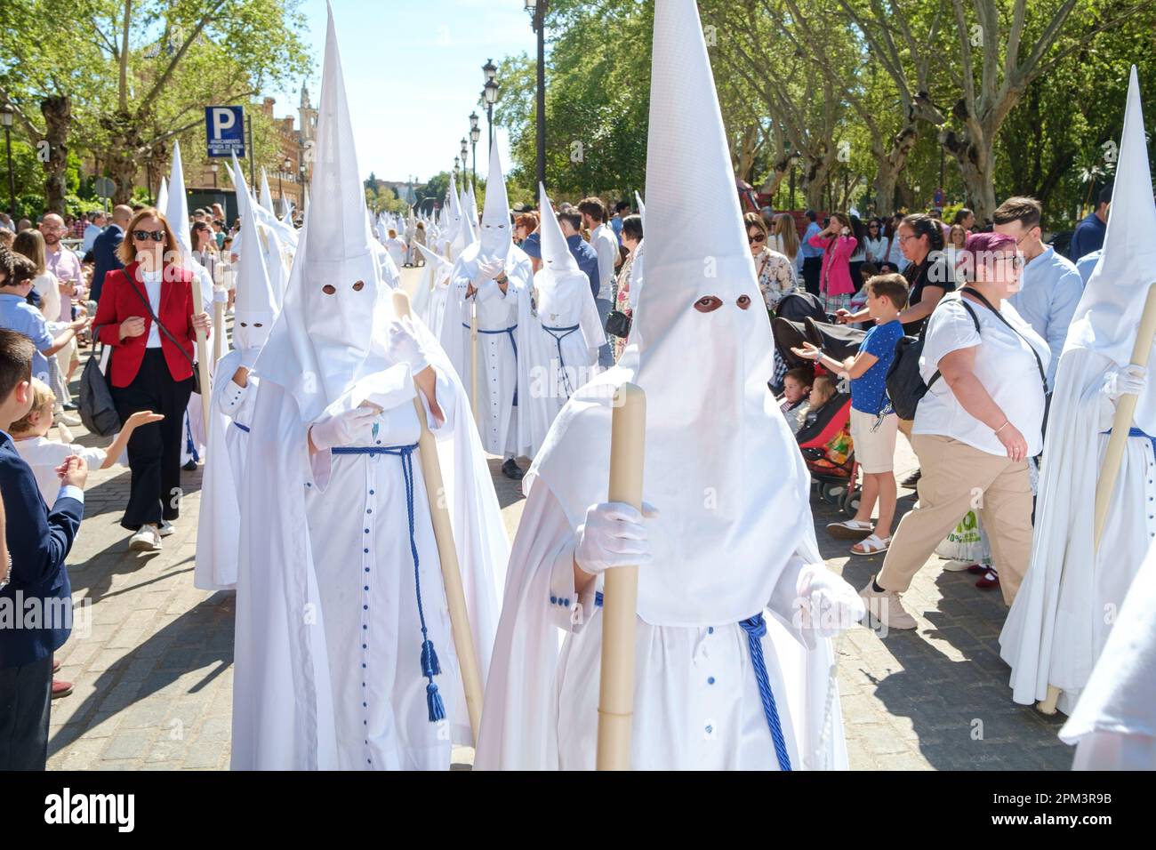 Seville Spain. Holy Week, Semana Santa. Palm Sunday. Participants wearing nazareno or penitential robe with a Capirote, a conical pointed hat. Stock Photo