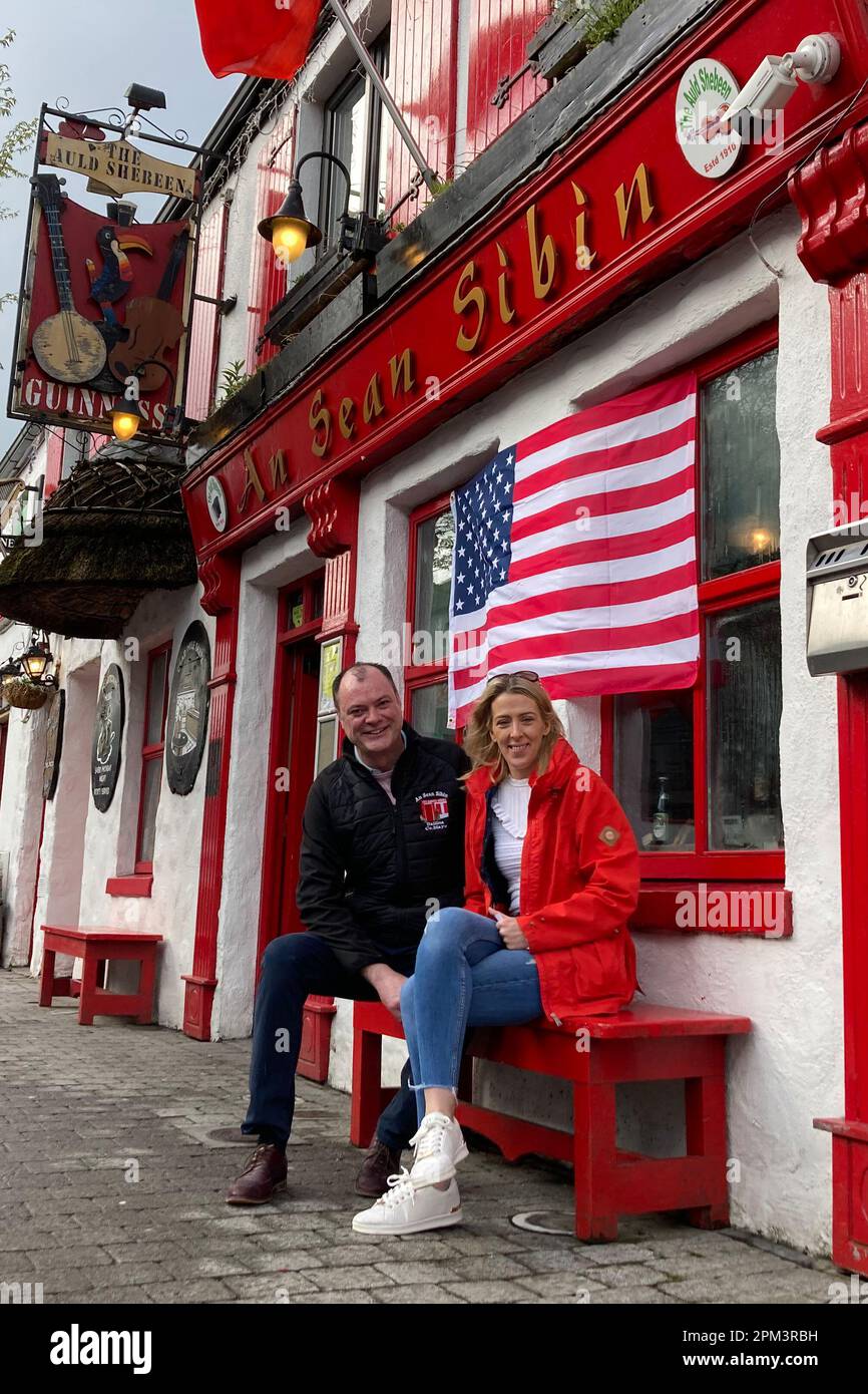 10 April 2023, Ireland, Ballina: Michelle and Cathal Sweeney are sitting outside their pub. Michelle dreams of being able to tap U.S. President Biden a beer in her store. Biden, whose ancestors are partly from the small town in the west of Ireland, is expected in Belfast in neighboring Northern Ireland on Tuesday evening (April 11) to celebrate the 25th anniversary of the Good Friday Agreement. Then as now, the U.S. was seen as the guarantor power of the agreement, which was at times seen as under threat due to Britain's exit from the EU. (to dpa ''Welcome Home Mr. President!' - Joe Biden in N Stock Photo