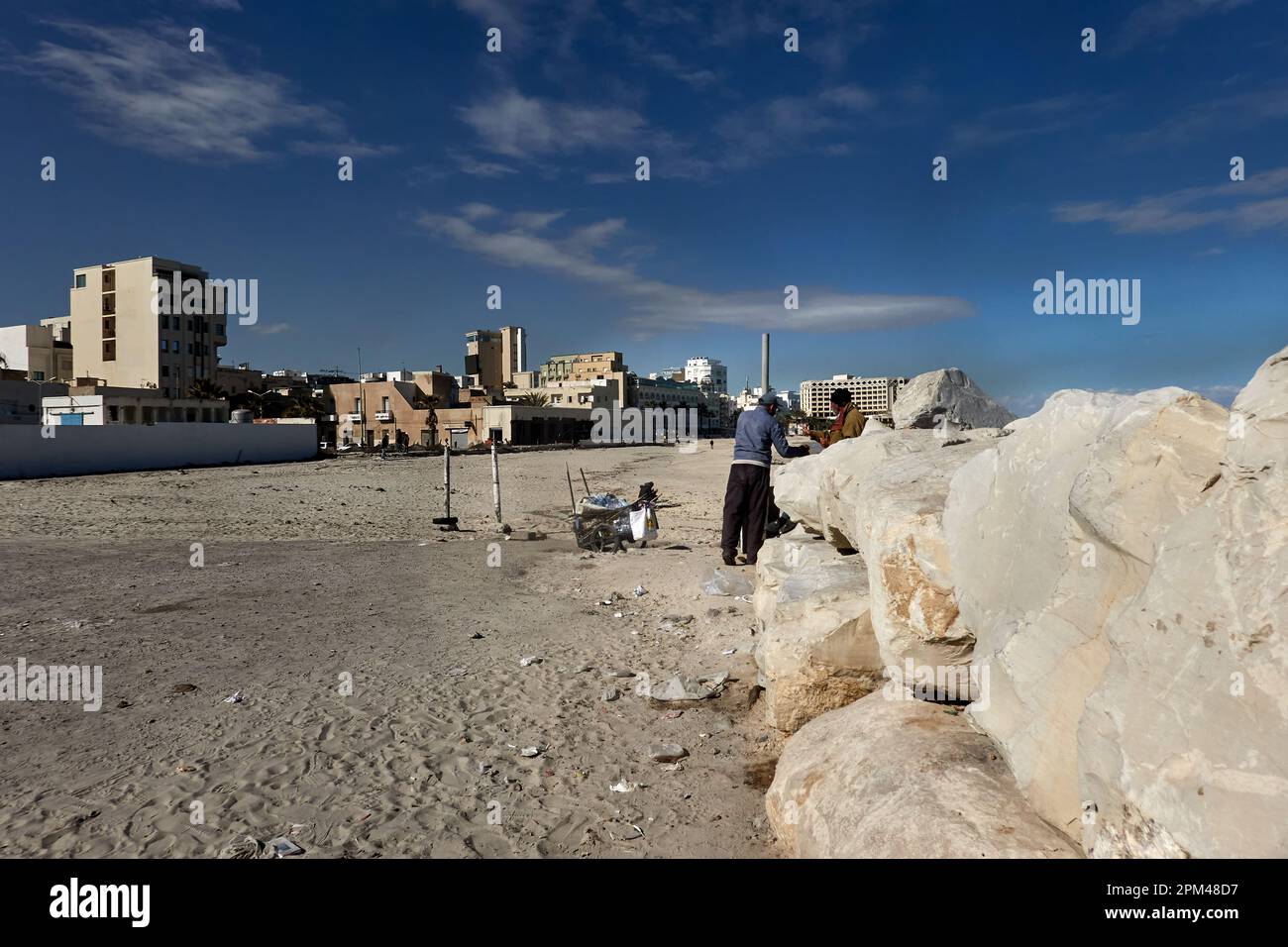 Sousse, Tunisia, January 24, 2023: Southern part of Boujavaar beach with rock embankment and a collector of plastic waste on the beach Stock Photo