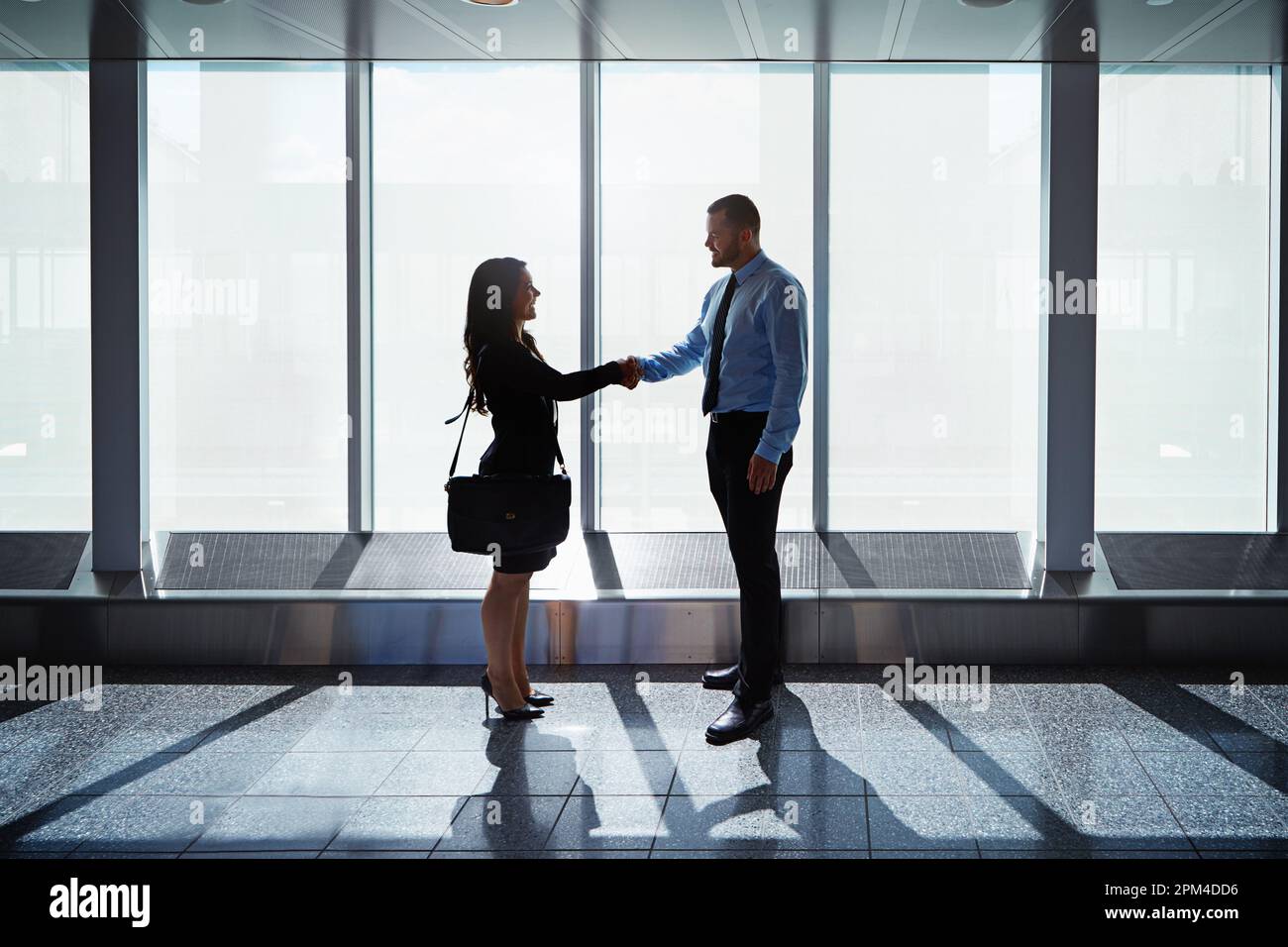 Meeting contacts at arrivals. two businesspeople shaking hands together