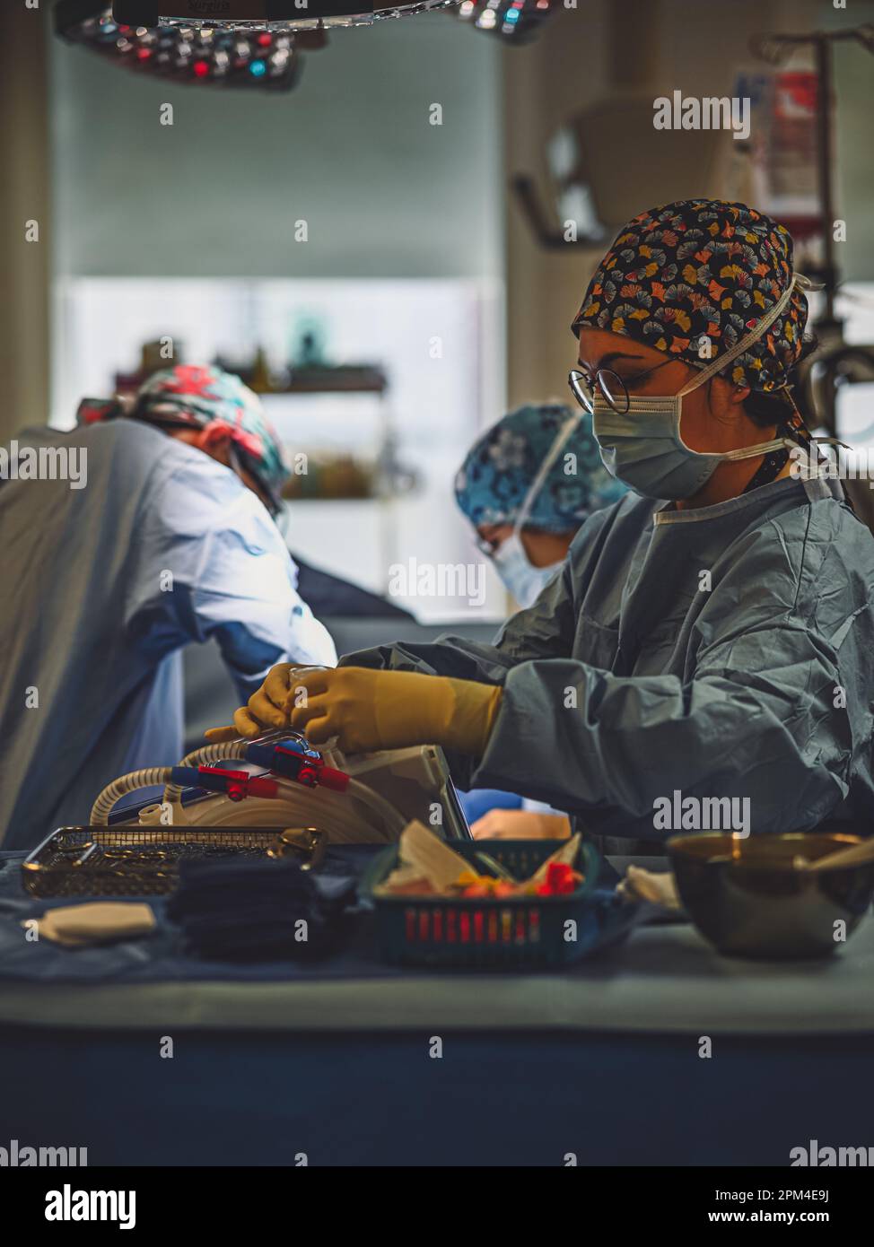 Two medical professionals wearing blue lab coats stand in a brightly ...