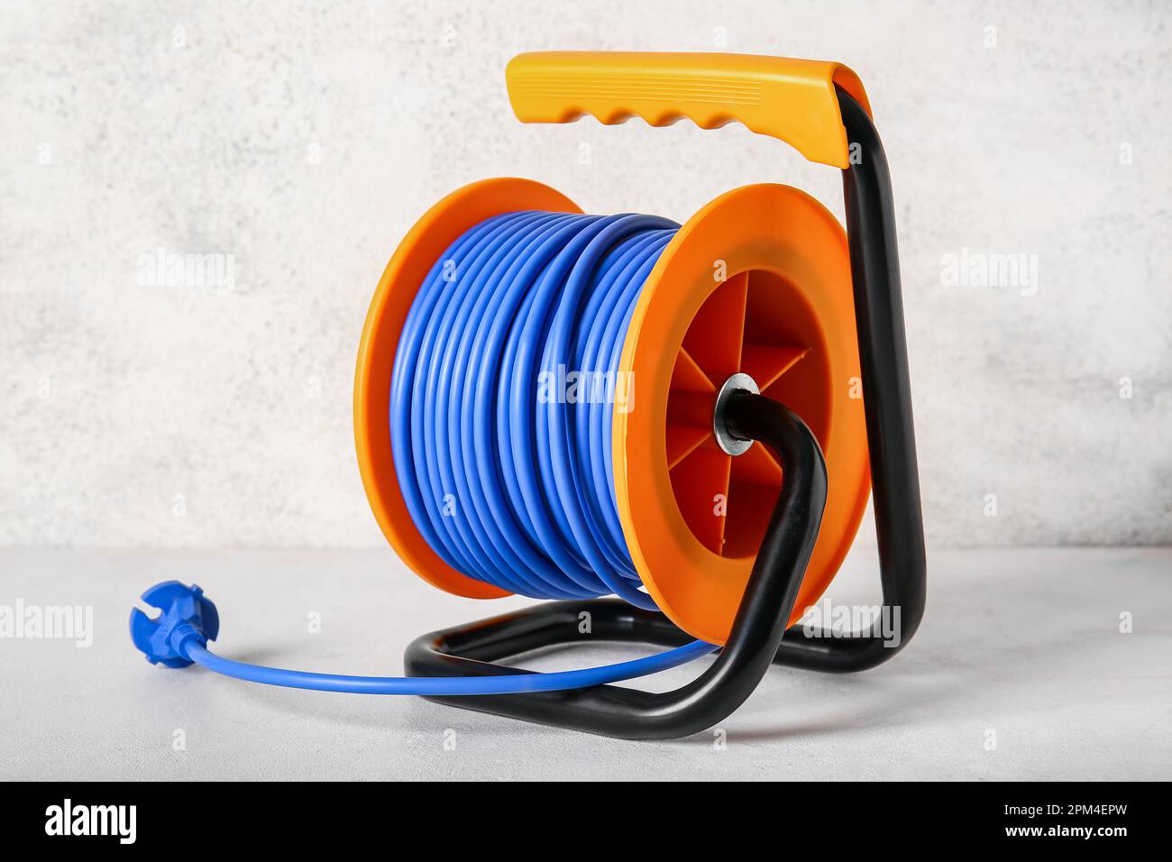 Extension electric cable reel on light background Stock Photo - Alamy