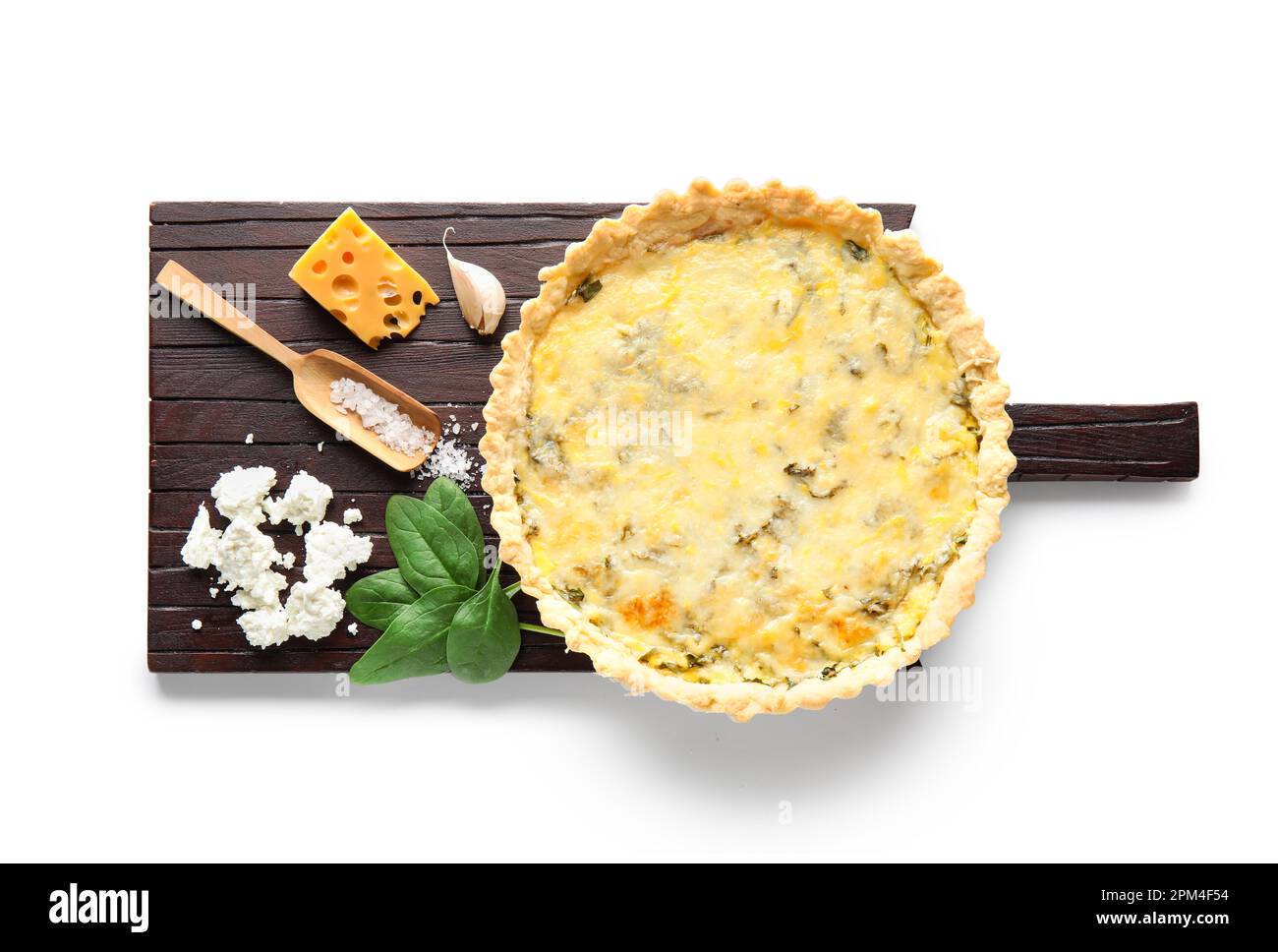 Board with delicious quiche, cheese and spinach leaves isolated on