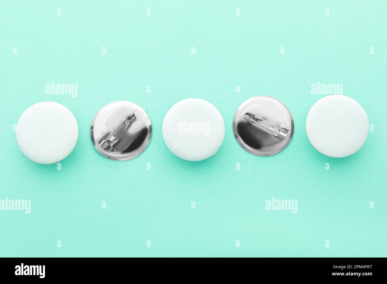 Blank white badges on turquoise background Stock Photo - Alamy