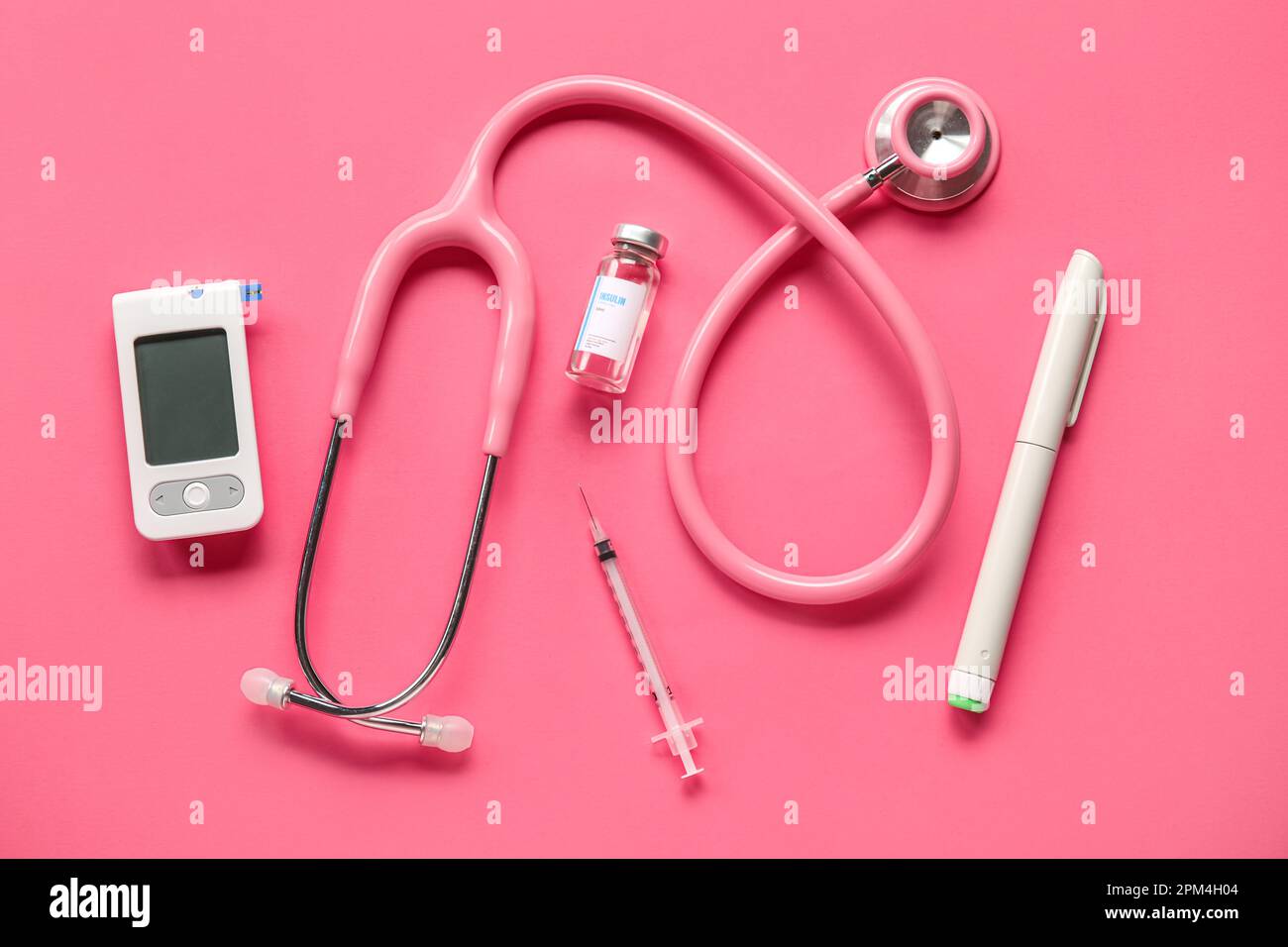 with insulin, lancet pen and stethoscope on pink background