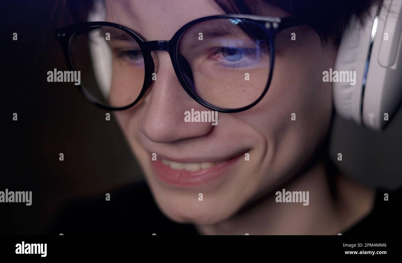 Gamer Reflection Young gamer man in glasses with screen reflection and headphones ...
