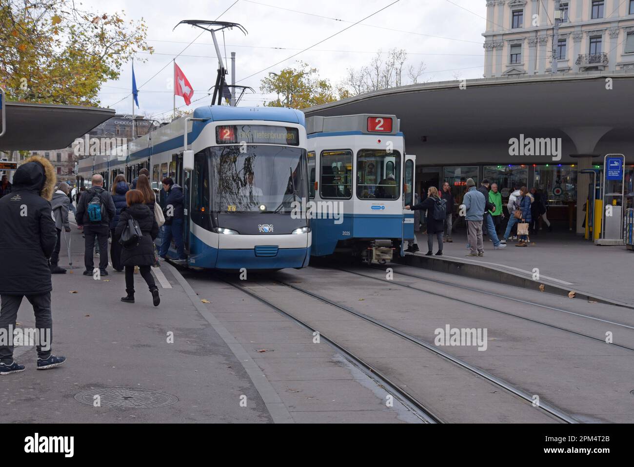 Passengers catching trams at the Bellevue tram stop, Zurich, Switzerland, November 2022 Stock Photo