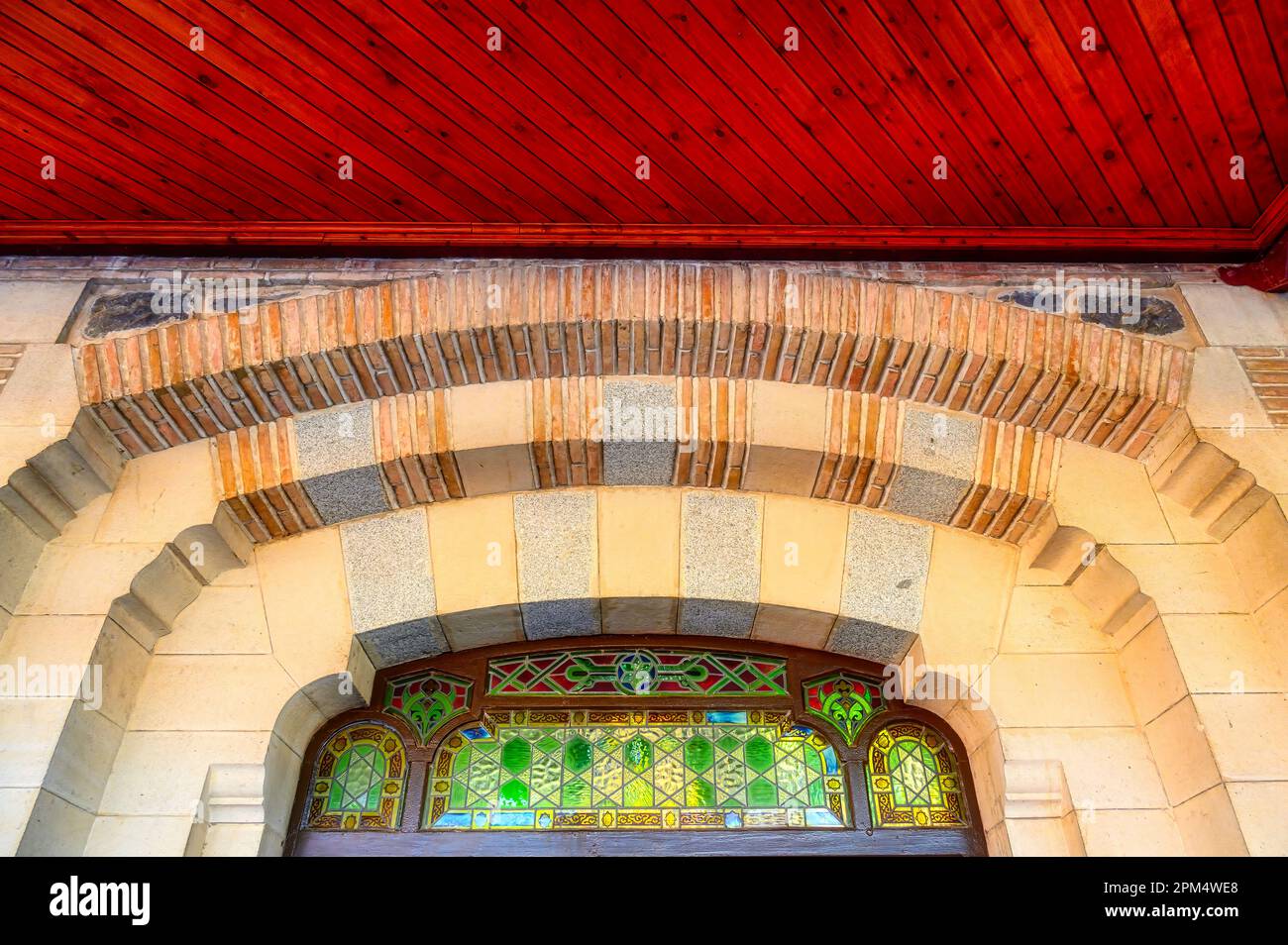 Detail of arched window with stained glass and part of the ceiling. Old antique architecture of the Toledo AVE station. The transportation building is Stock Photo