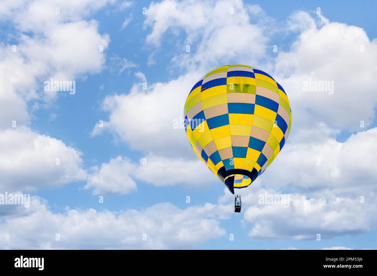 Colorful hot air balloon flying over blue sky with white clouds Stock ...