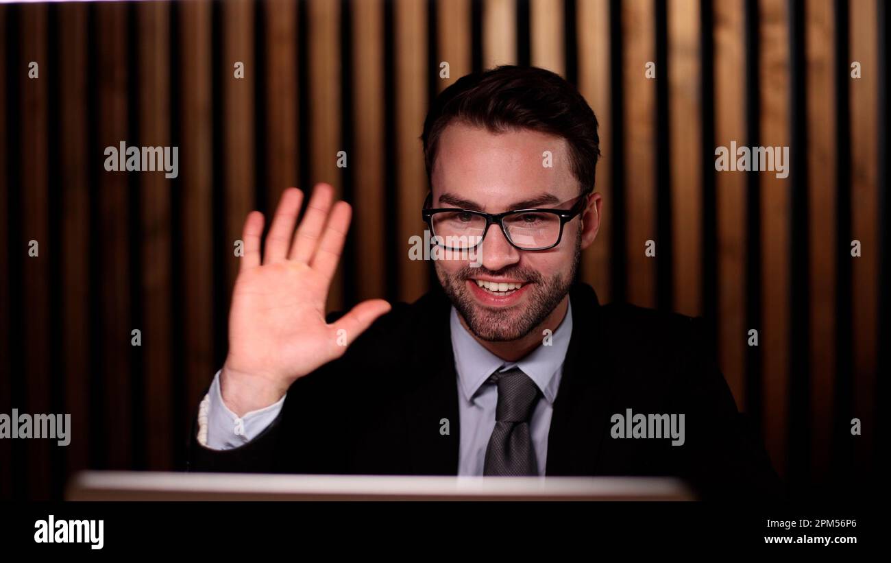 Young handsome businessman goodbye to the client and waves his hand. Stock Photo