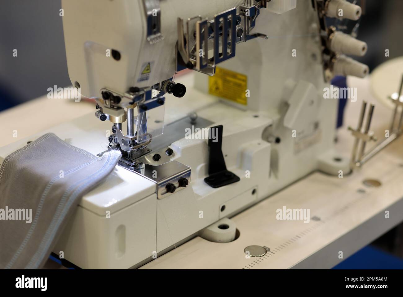 Industrial coverstitch sewing machine close up. Selective focus Stock