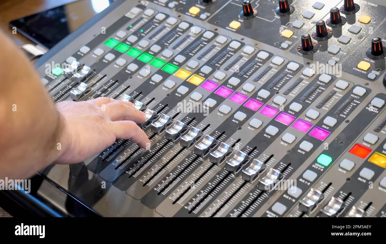 A male sound engineering running live sound for a local band on a