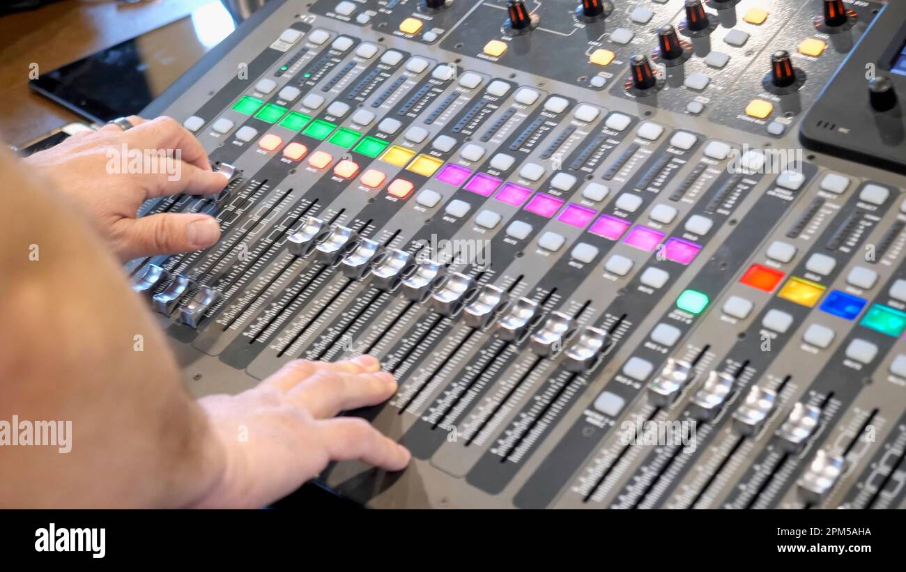 A male sound engineering running live sound for a local band on a