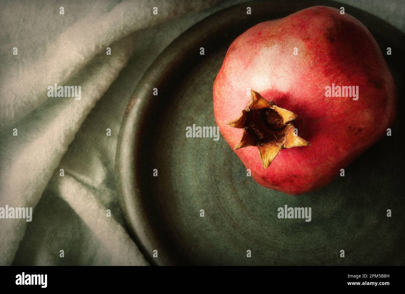 One pomegranate on round plate close up Stock Photo