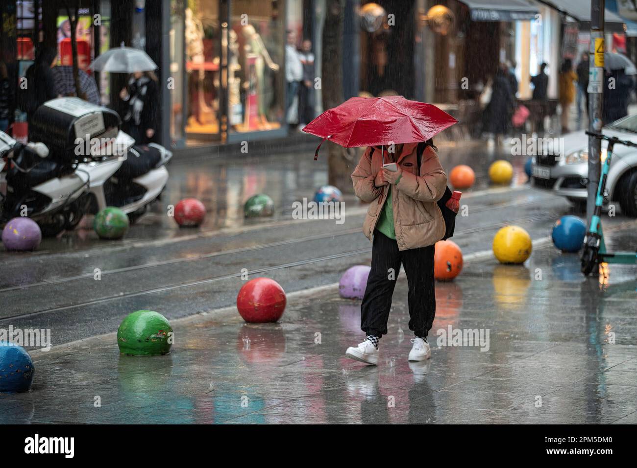 A person holds an umbrella to protect herself from the heavy rainfall ...