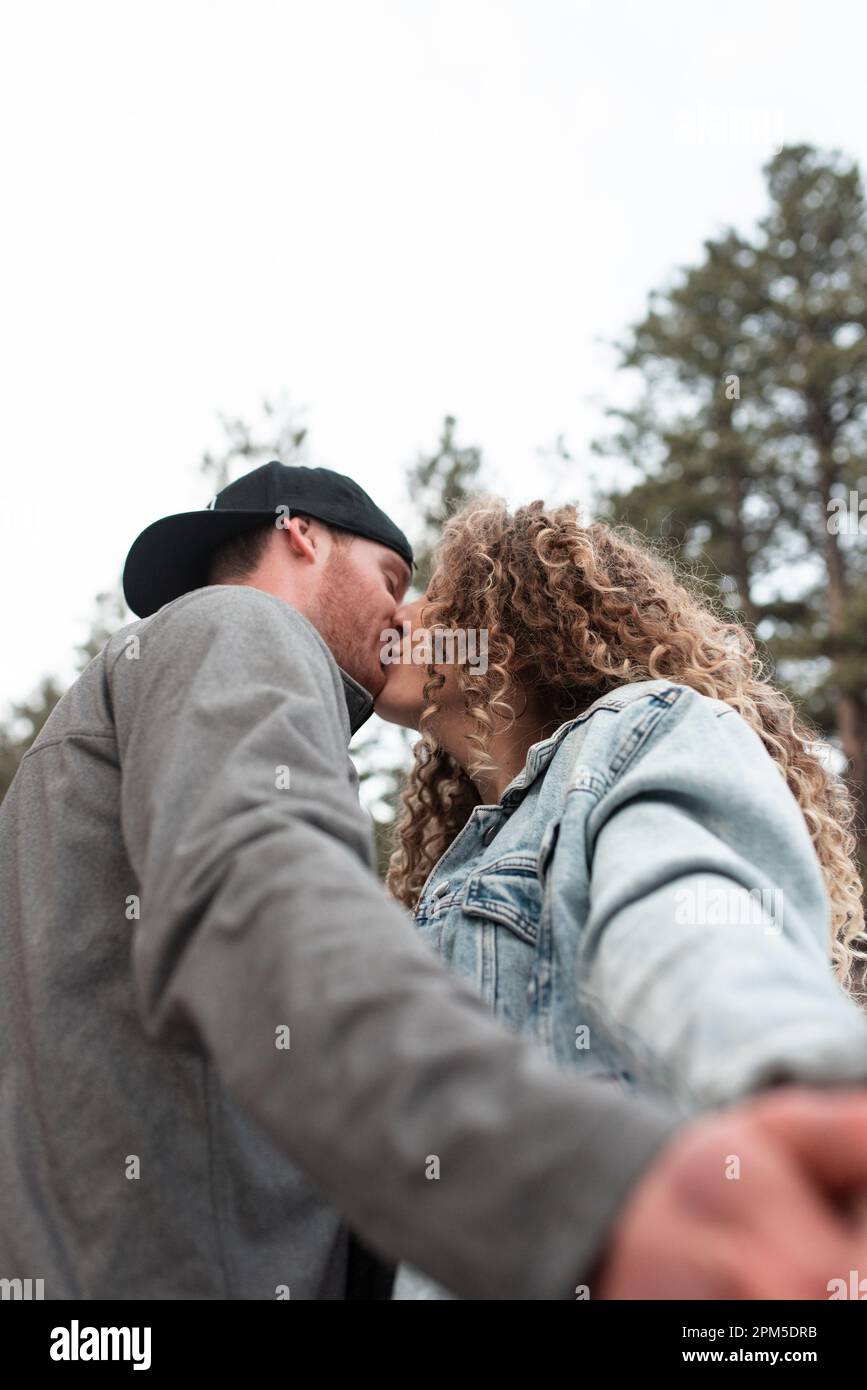 Adventurous Young Couple Kissing in Colorado Mountains in Winter Stock Photo