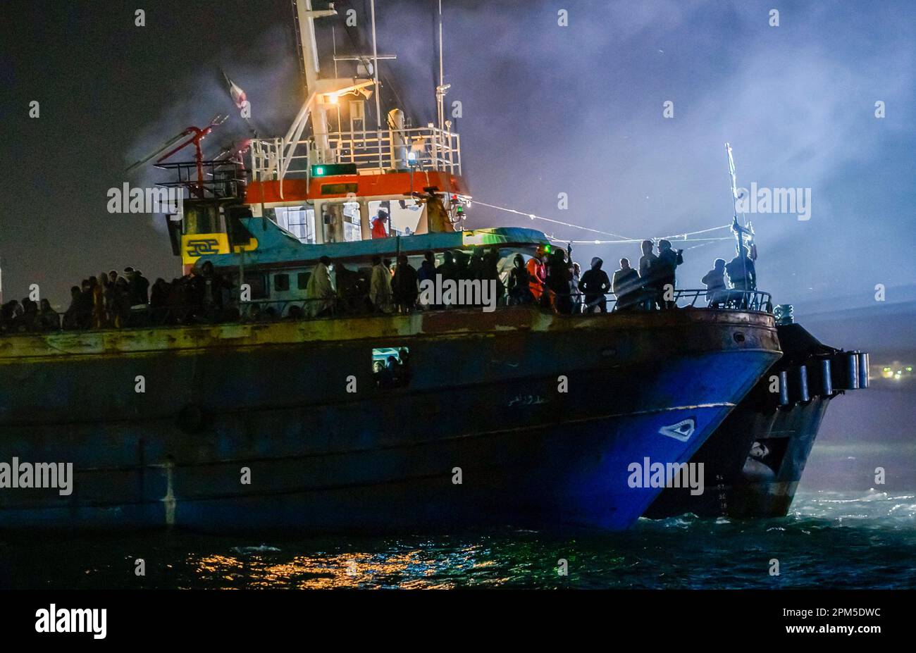FILE - A fishing boat with some 500 migrants enters the southern