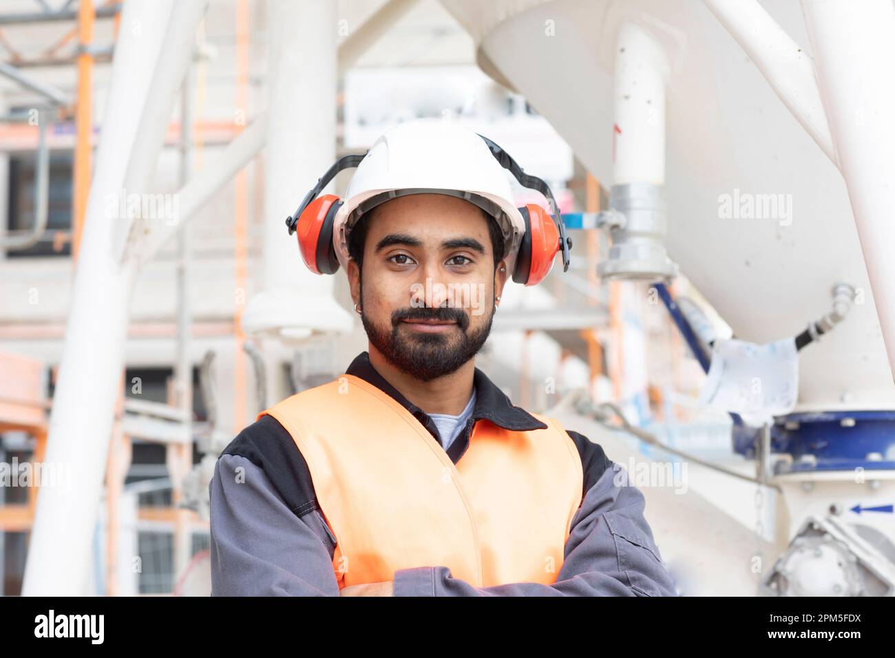young technician safety vest and helmet working Stock Photo