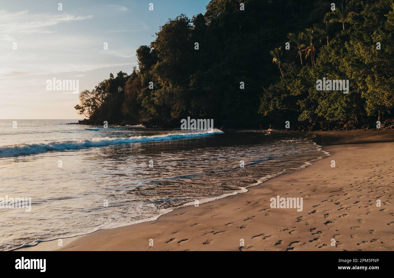 Waves rolling in on a warm sandy beach in Costa Rica. Stock Photo
