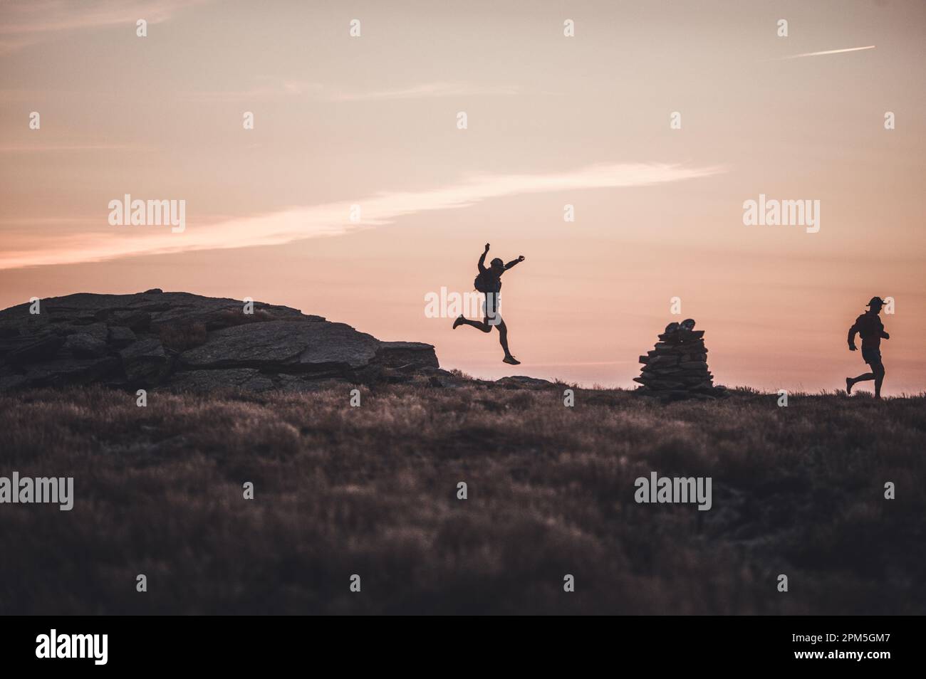 Silhouette male trail runners running over ridge at dawn sunrise Stock ...