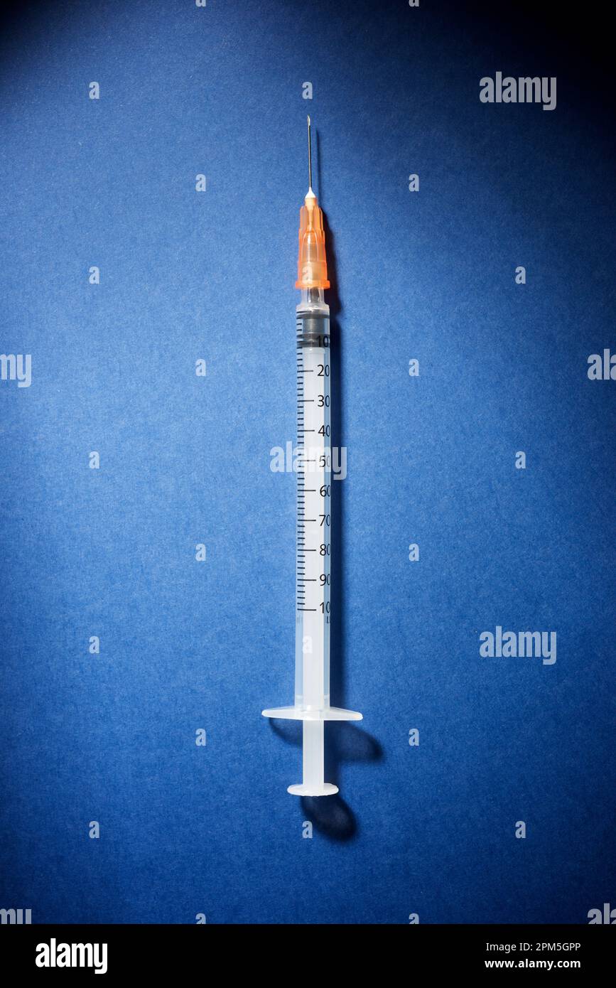 Hypodermic syringe on a blue table Stock Photo Alamy