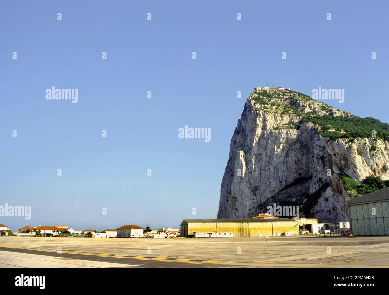Road crossing the runway of Gibraltar's Airport with the rock of Gibraltar Stock Photo
