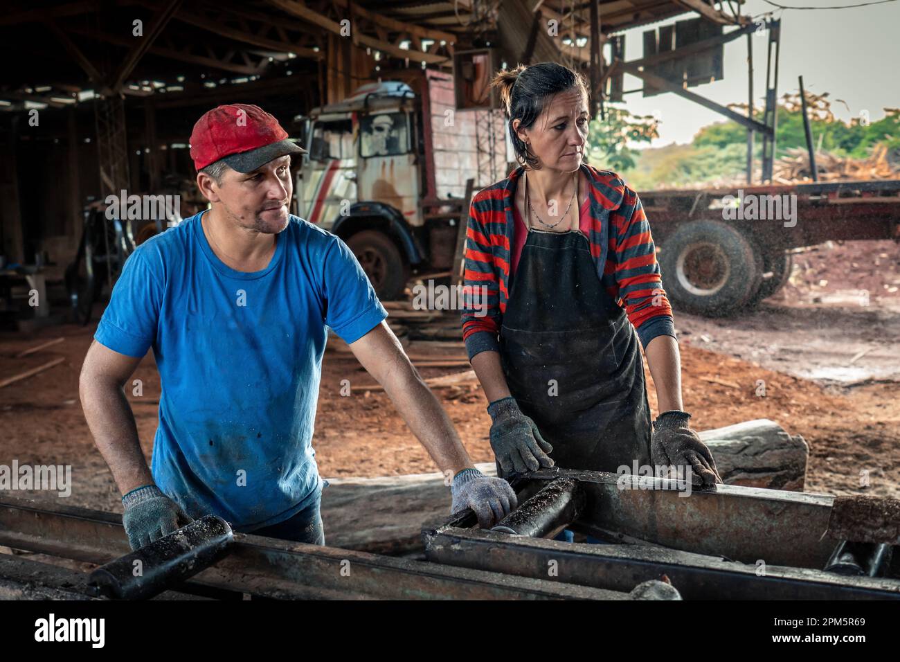 Husband and wife work together in a sawmill. Family business. Manual