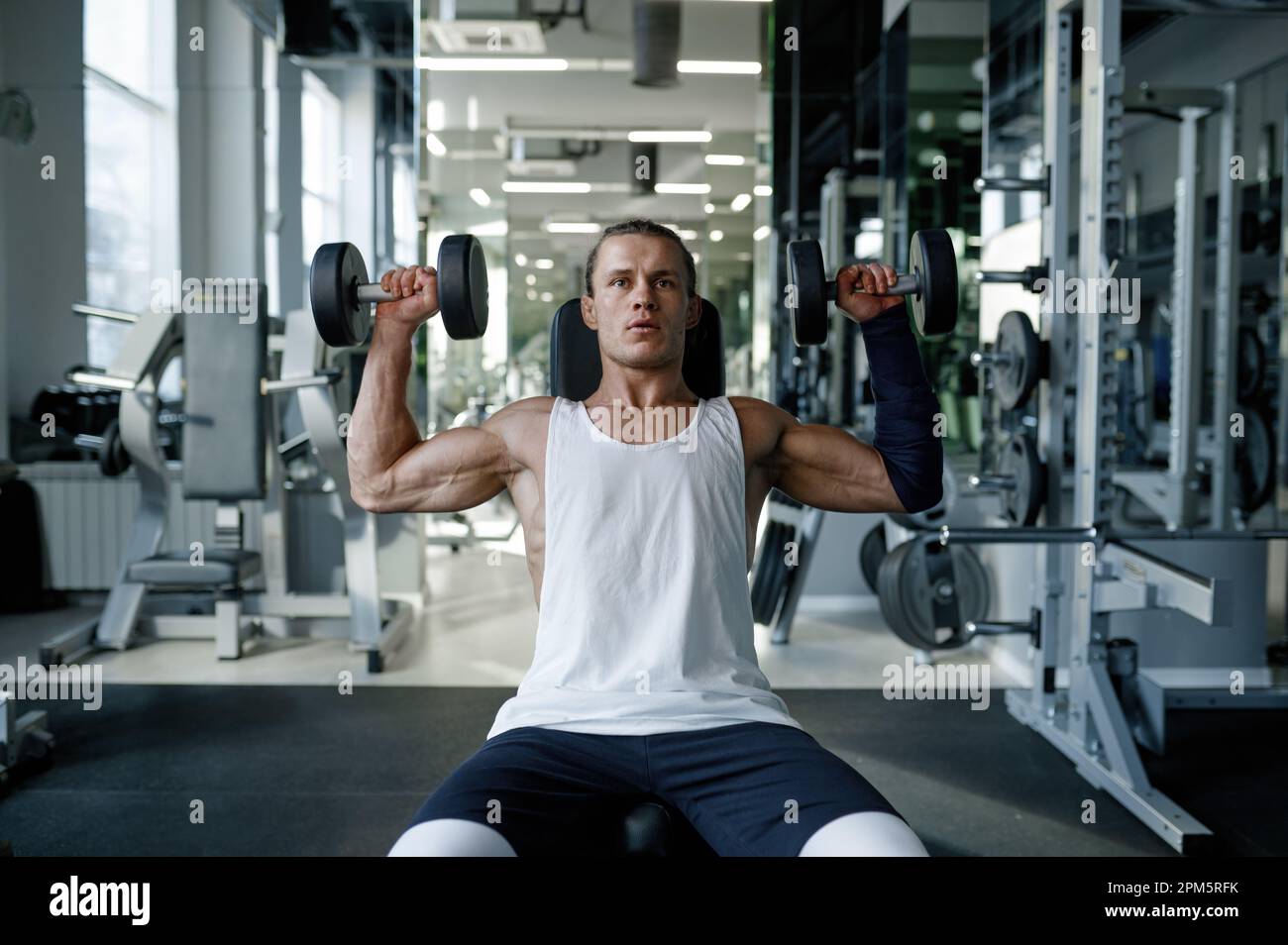 Strong healthy bodybuilder doing fitness training with dumbbells on ...