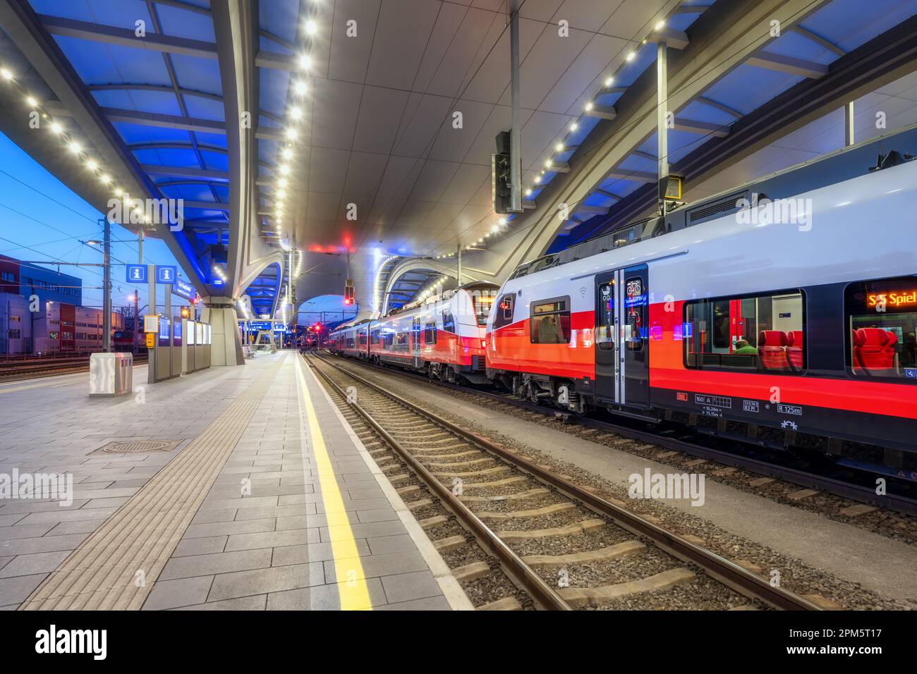 High speed train on the modern railway station at night Stock Photo - Alamy
