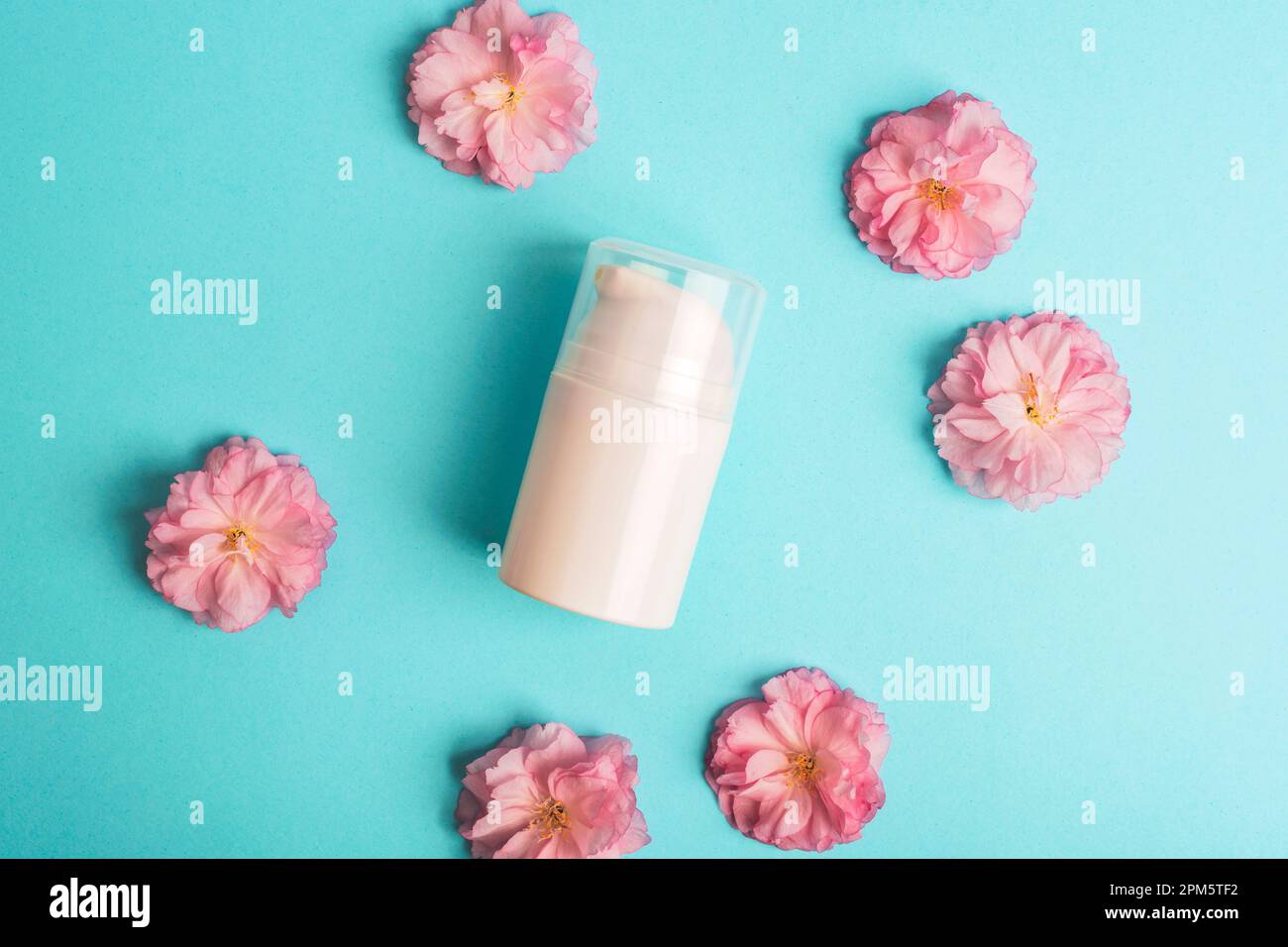 Cosmetic white blank dispenser bottle and sakura blossom on blue