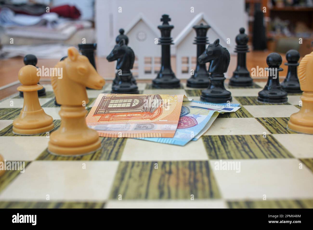 euro notes on the chessboard to make the right decisions and buy houses Stock Photo