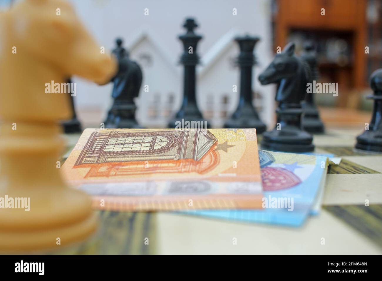 euro notes among chess pieces. Concept, thinking about where is the best place to invest them Stock Photo