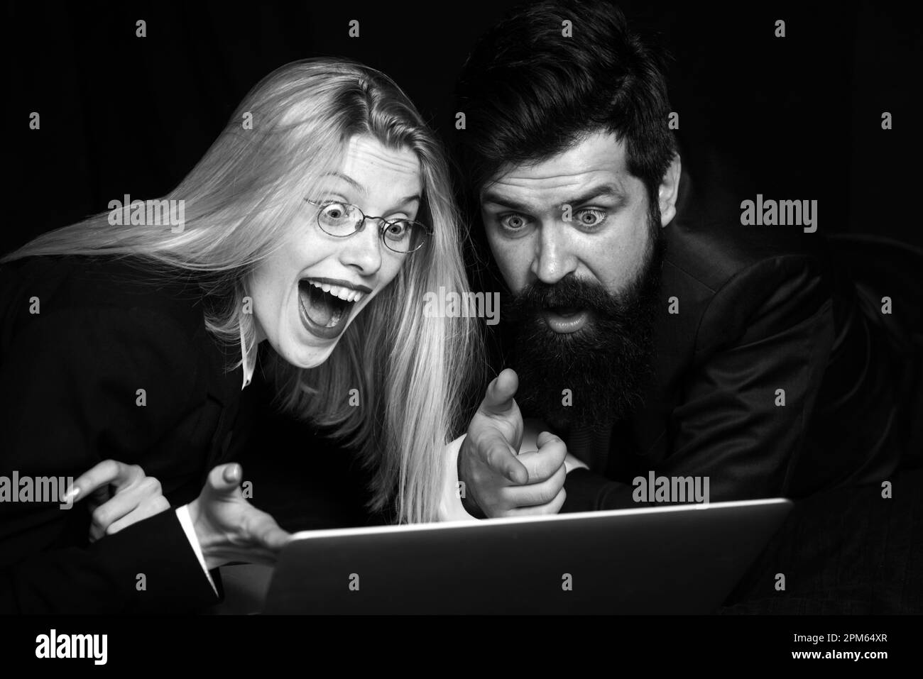 Excited couple rejoice in winning an internet lottery made bets on website. Happy couple celebrating victory in online competitions enjoying success Stock Photo
