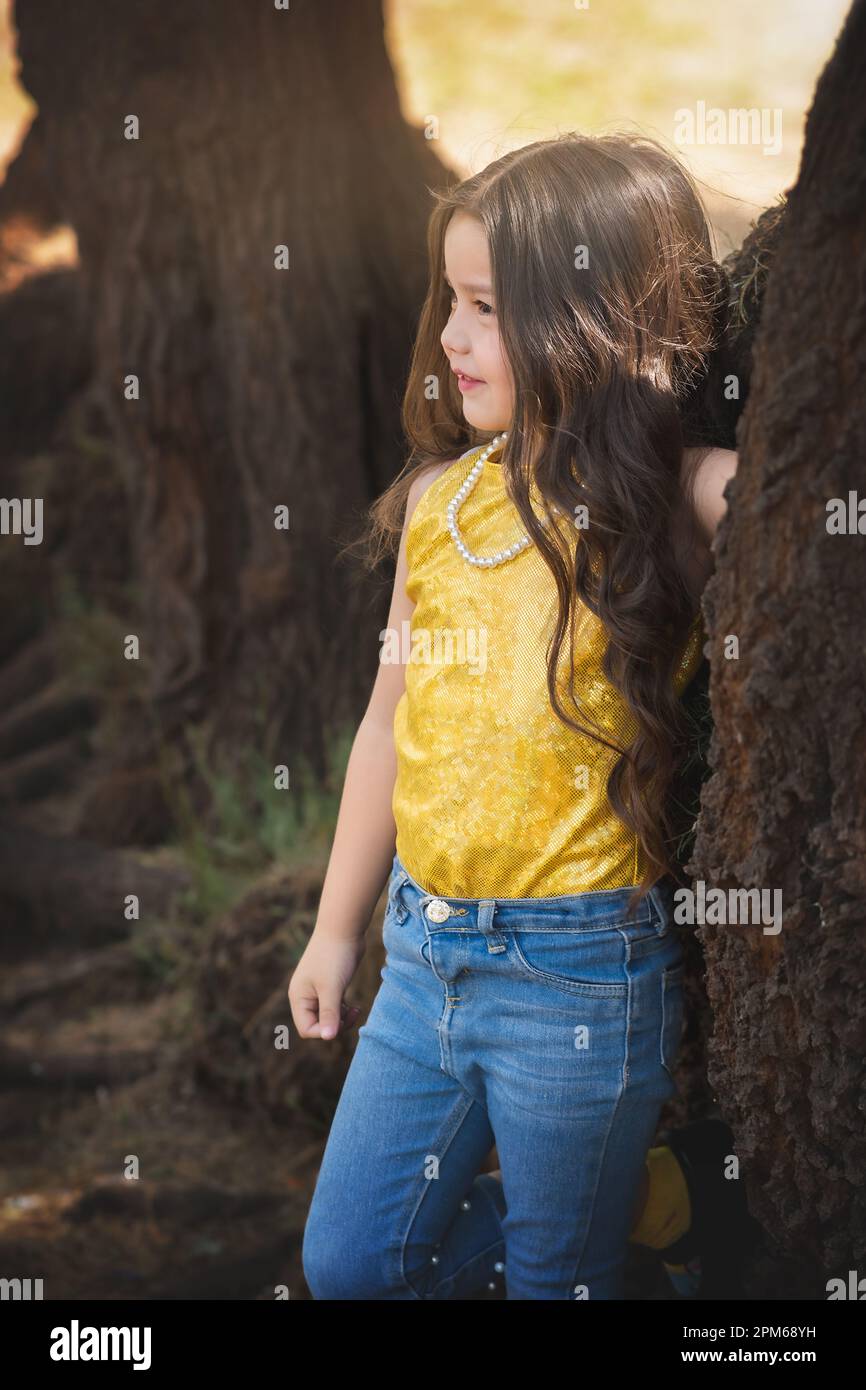Blonde girl in a photo session posing in a tree. Expressions of happiness. Model girl. children's day theme. Stock Photo