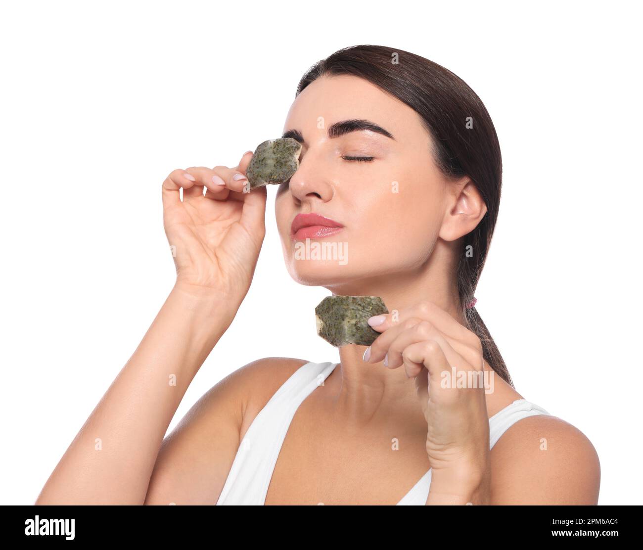 Beautiful woman applying green tea bags on skin under eyes against