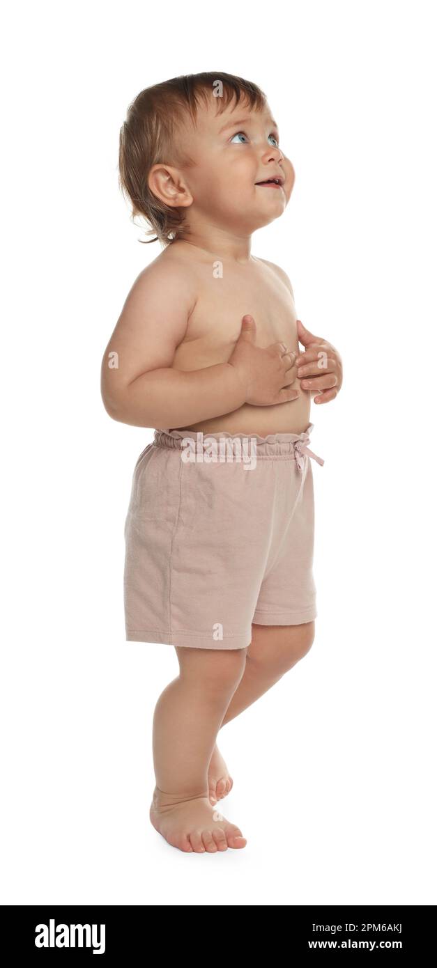 Cute baby in shorts learning to walk on white background Stock Photo